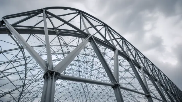 Fondo de pantalla 4K IA: Vista inferior de estructura metálica industrial contra nubes