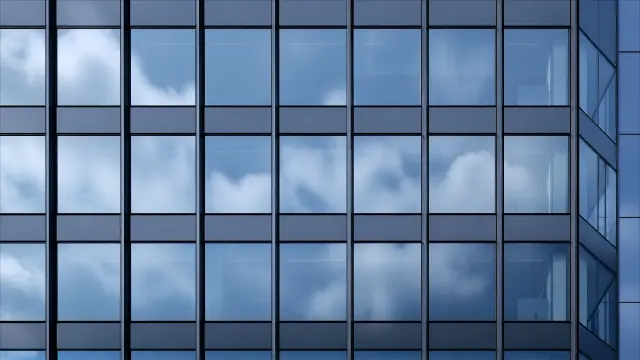 Fondo de pantalla 4K IA: Fachada de cristal con nubes reflejadas