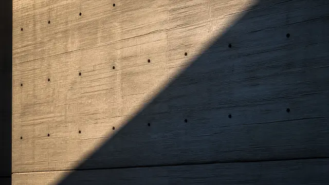 Fondo de pantalla 4K IA: Pared de hormigón con luces y sombras al atardecer