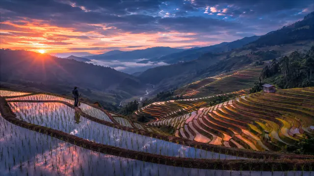 Atardecer en terrazas de arroz con agricultor