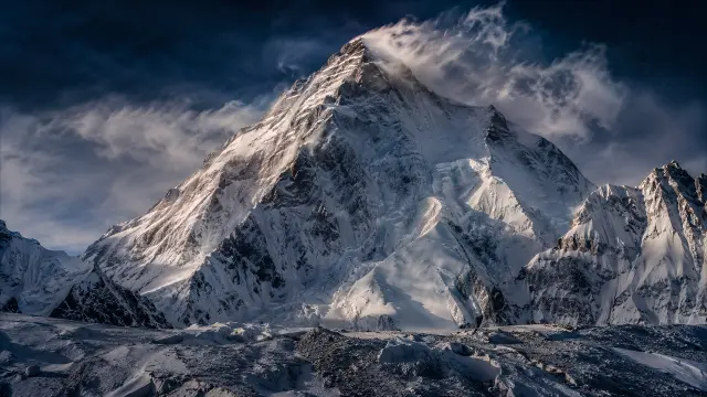 Majestuosa montaña nevada bajo un cielo dramático
