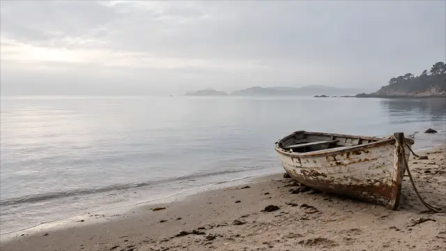 Barco oxidado en playa con niebla y calma