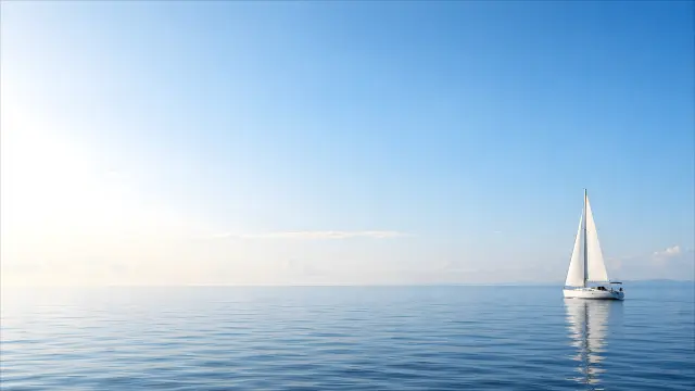 Velero blanco navegando en un mar azul sereno