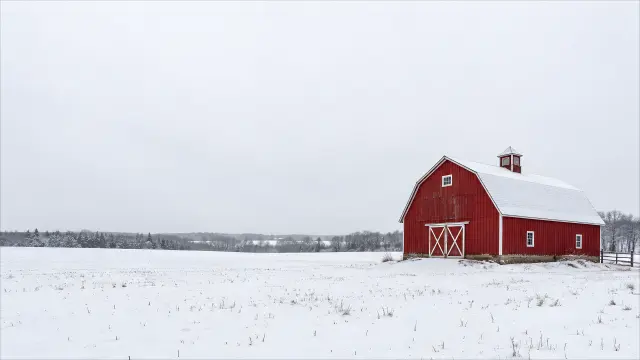 Granero rojo clásico en campo nevado minimalista