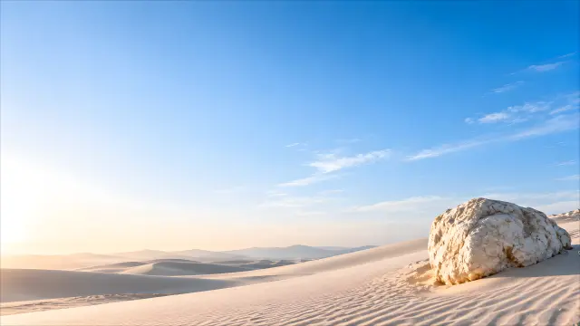 Dunas de arena blanca con roca y cielo azul