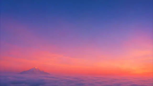 Montaña nevada sobre nubes al amanecer