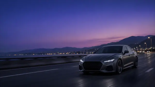 Coche deportivo gris en autopista al atardecer