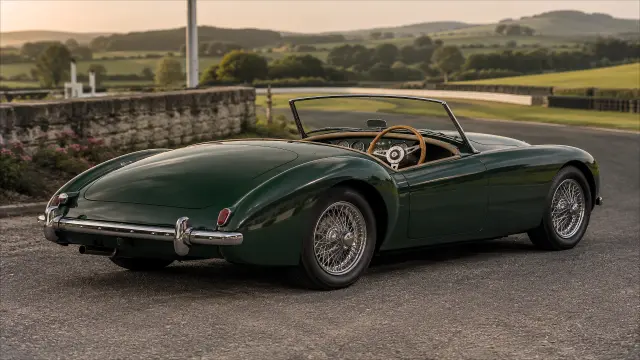 Coche clásico verde en carretera de campo al atardecer — fondo coches y motos IA