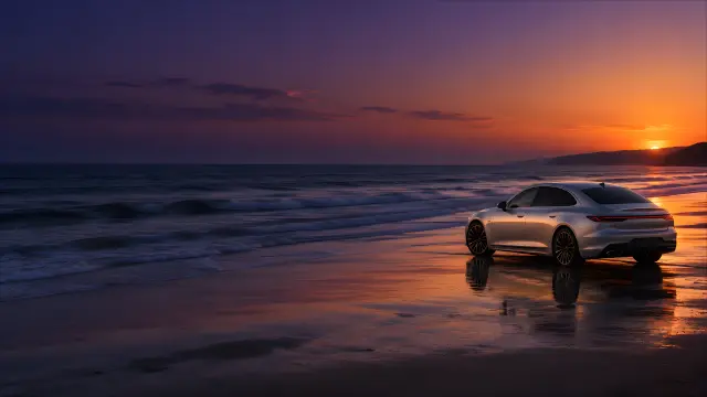 Coche deportivo plateado en la playa al atardecer