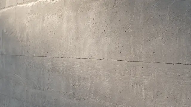 Fondo de pantalla 4K: Textura de concreto gris con grieta horizontal y agujeros en la pared