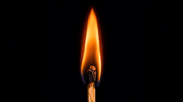 Antorcha ardiendo sobre fondo negro minimalista