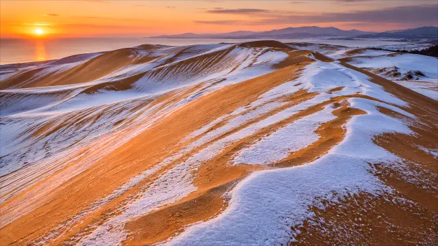 Dunas de arena y nieve al atardecer