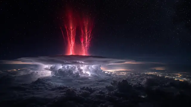 Tormenta eléctrica roja sobre nubes nocturnas estrelladas